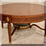 F16. Maitland Smith round mahogany and brass banded coffee table. Some small chips to finish. 17.5”h x 36”w - $750